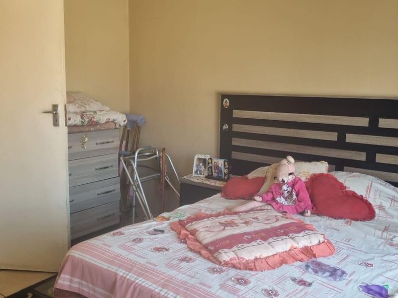 A functional bedroom featuring tiled flooring and a built-in headboard, offering a neutral base for personalization.