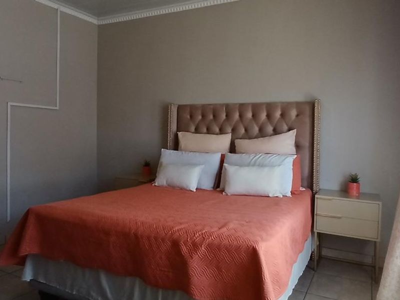 A bedroom featuring tiled flooring and crown molding, with visible surface-mounted electrical conduit on the wall.