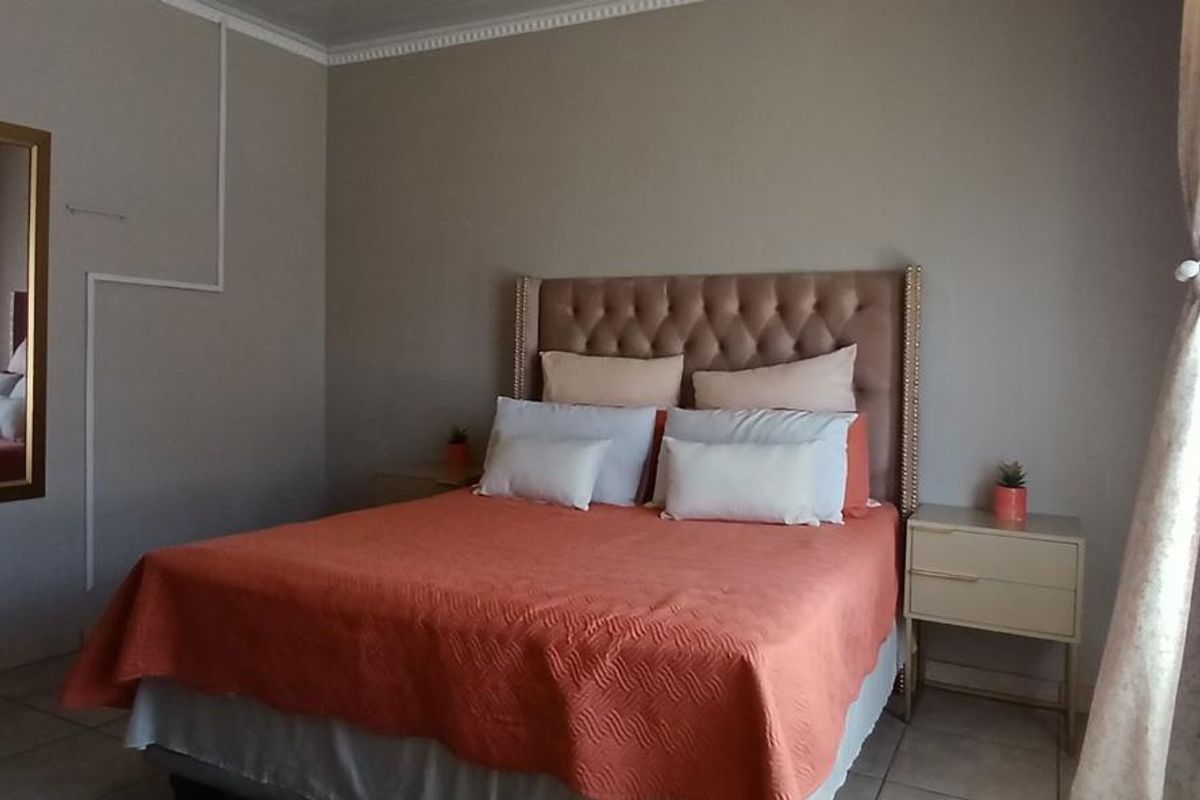 A bedroom featuring tiled flooring and crown molding, with visible surface-mounted electrical conduit on the wall.