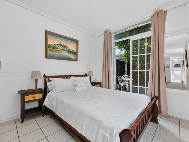 A bedroom featuring tiled flooring and a sliding glass door providing direct access to an outdoor patio area.