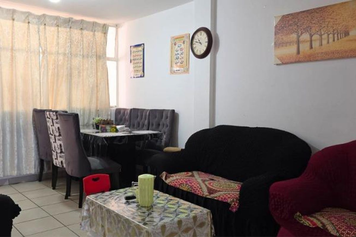 A living and dining area featuring tiled flooring and a large window, providing a functional space for relaxation and meals.