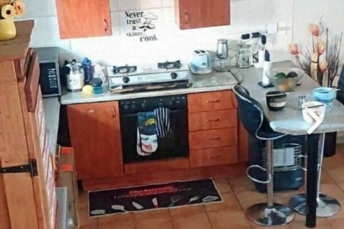 Compact kitchen featuring wooden cabinetry, built-in oven, gas cooktop, and tiled flooring.