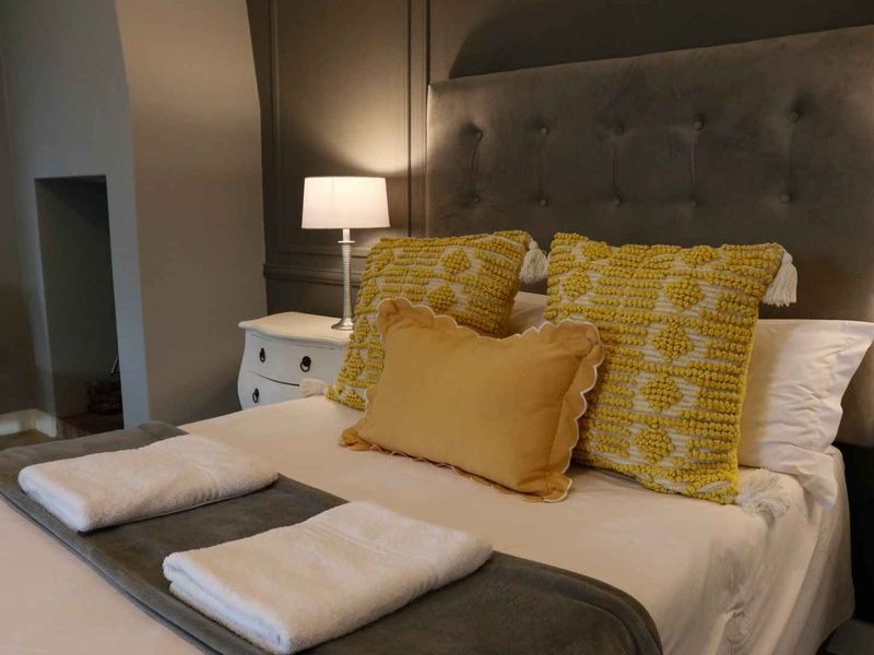 A well-presented bedroom featuring elegant wall paneling and a recessed alcove, creating a cozy and refined atmosphere.