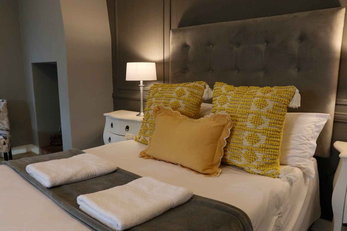 A well-presented bedroom featuring elegant wall paneling and a recessed alcove, creating a cozy and refined atmosphere.