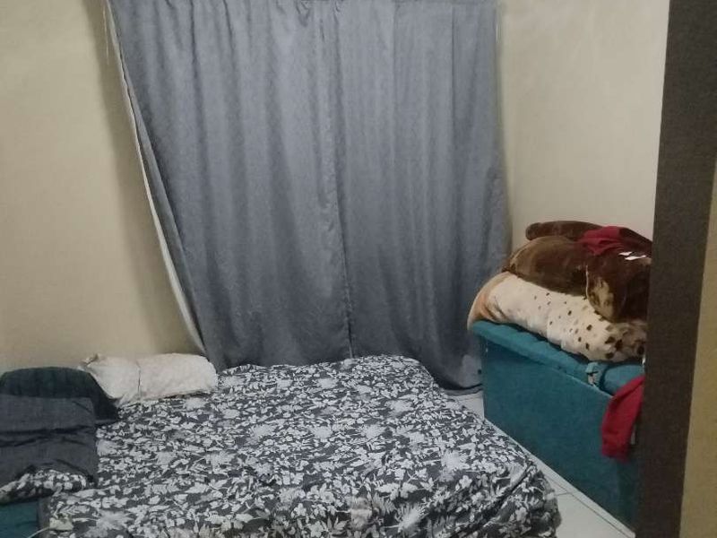 A bedroom featuring tiled flooring and a curtain rail, providing a functional space ready for personalization.