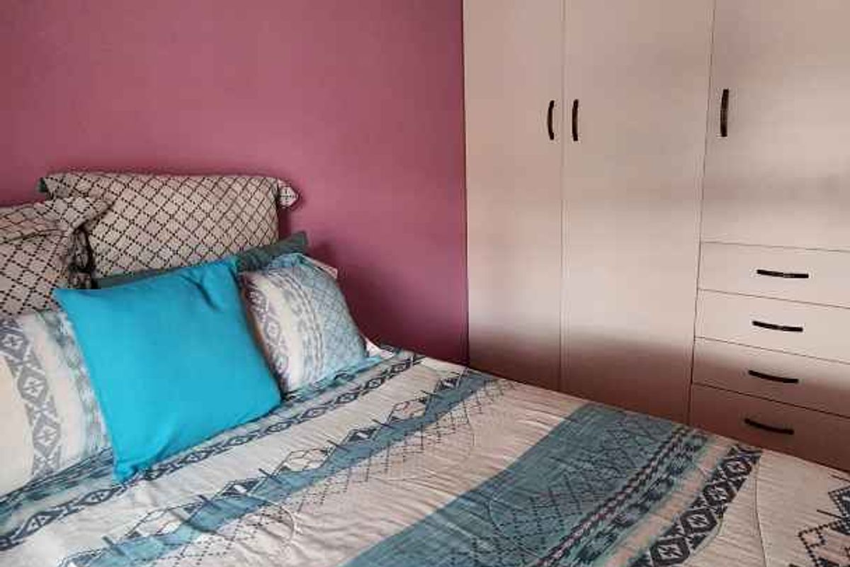 A bedroom featuring a built-in wardrobe with integrated drawers and coving detail.