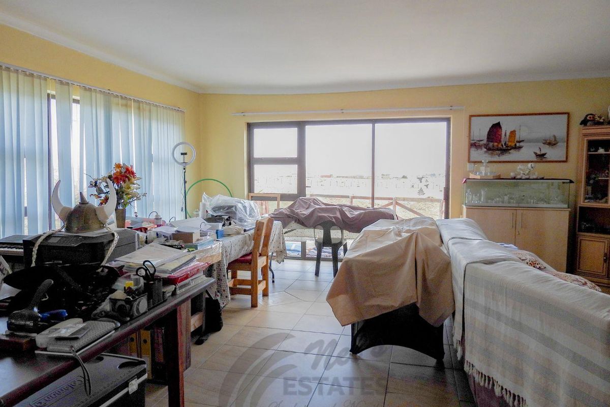 Spacious living area featuring large windows and sliding glass doors that provide ample natural light and access to the exterior.