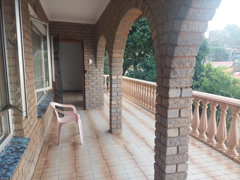 A covered balcony featuring classic brick arches and a balustrade, offering an outdoor space with potential for comfortable seating and relaxation.