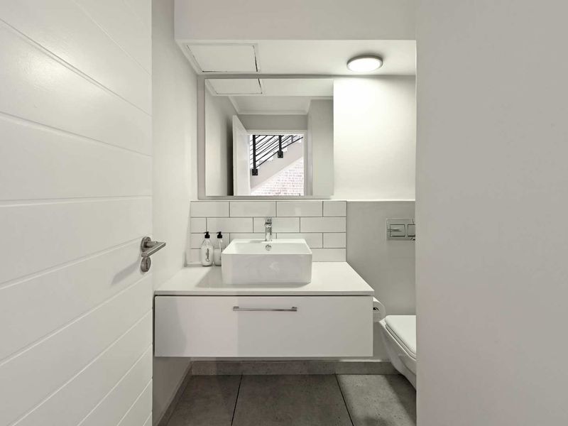 Modern guest bathroom featuring a wall-mounted vanity with a vessel sink, subway tile backsplash, and a wall-hung toilet.