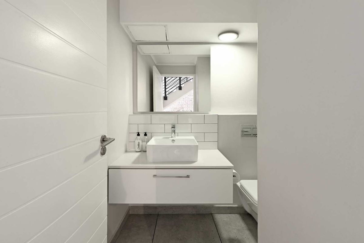 Modern guest bathroom featuring a wall-mounted vanity with a vessel sink, subway tile backsplash, and a wall-hung toilet.