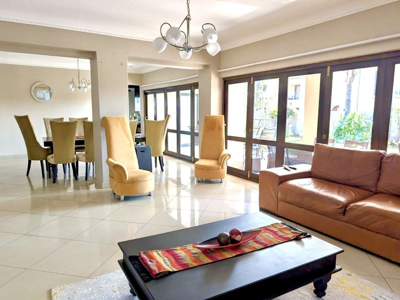 Spacious open-plan living and dining area featuring large glass sliding doors that provide ample natural light and seamless access to the outdoor patio.