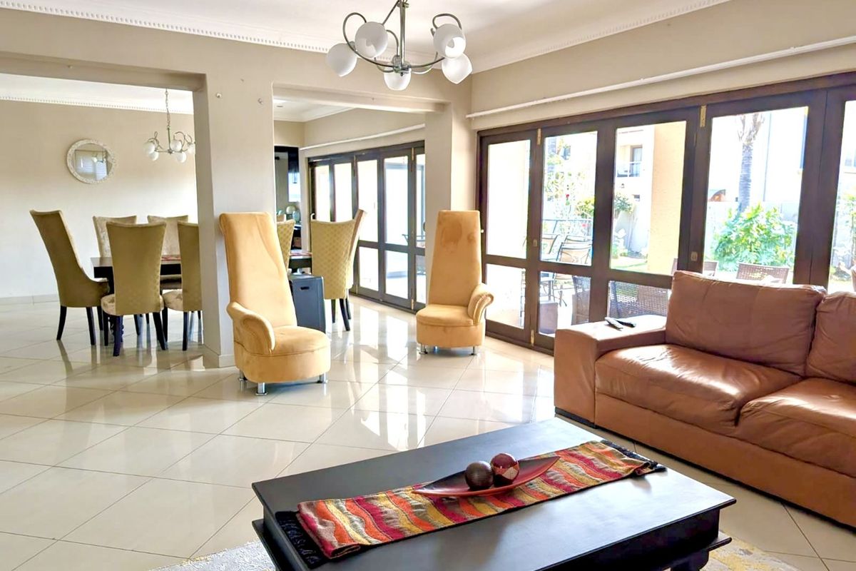 Spacious open-plan living and dining area featuring large glass sliding doors that provide ample natural light and seamless access to the outdoor patio.