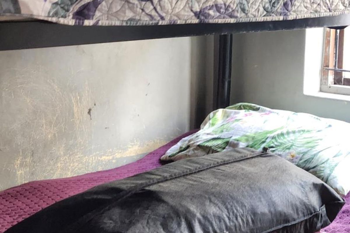 A bedroom featuring a bunk bed setup with visible wear on the wall surfaces.