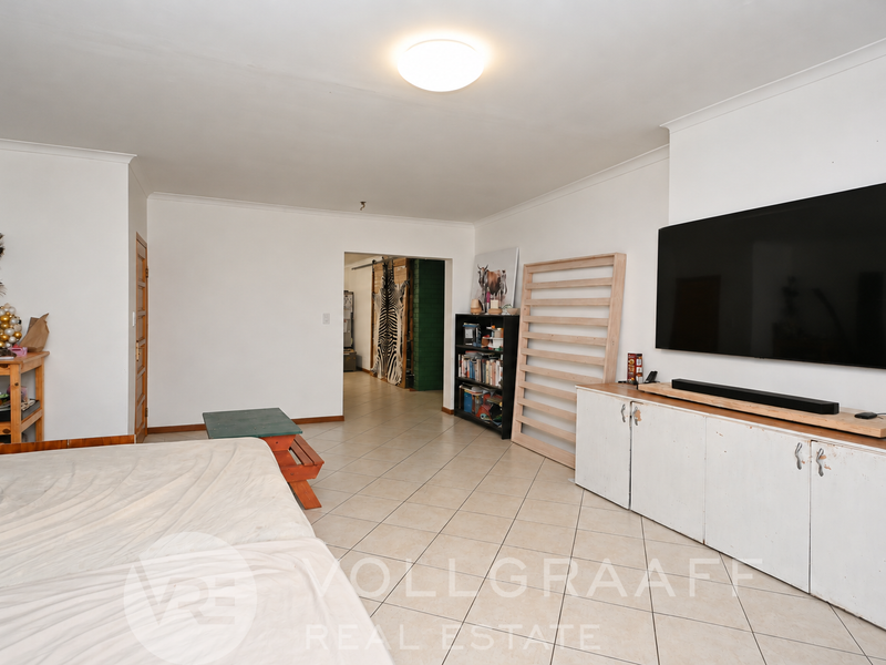 Spacious living area featuring neutral tiled flooring, built-in storage cabinetry, and a clean, open layout suitable for various furniture arrangements.