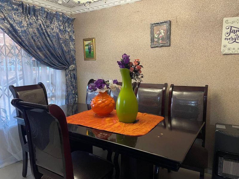 A dining room featuring textured wallpaper and decorative ceiling cornicing, providing a traditional aesthetic for the home.