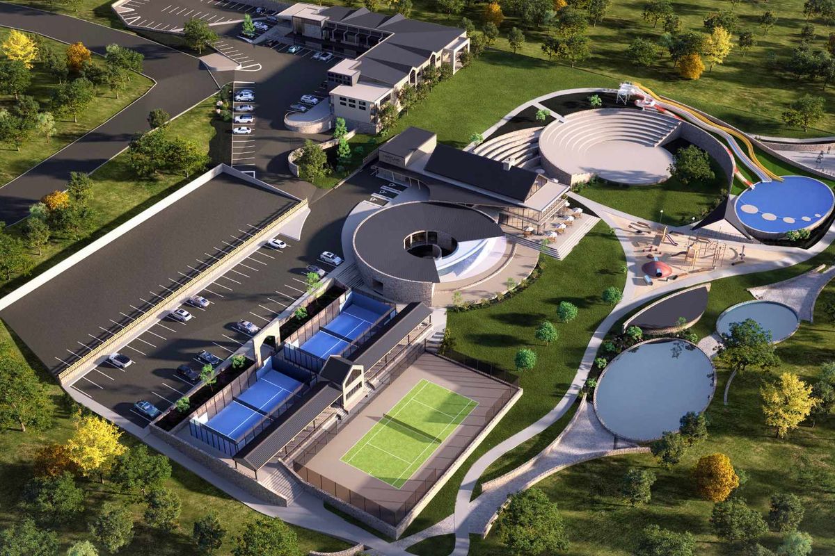 Aerial view of a modern residential estate featuring tennis and padel courts, a swimming pool, an amphitheatre, and extensive landscaped grounds.