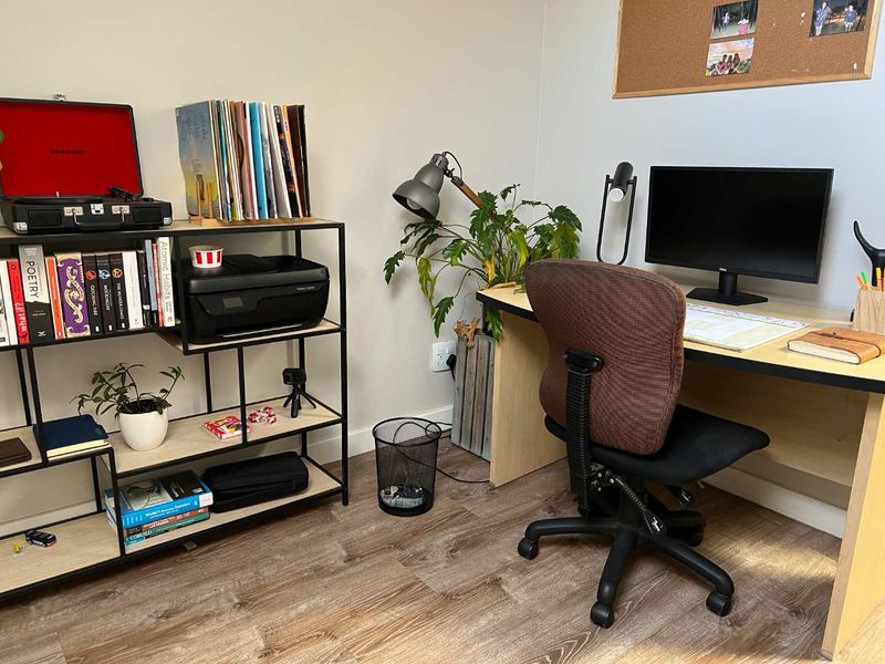A functional home office space featuring wood-look laminate flooring and neutral wall finishes, suitable for a dedicated workspace.