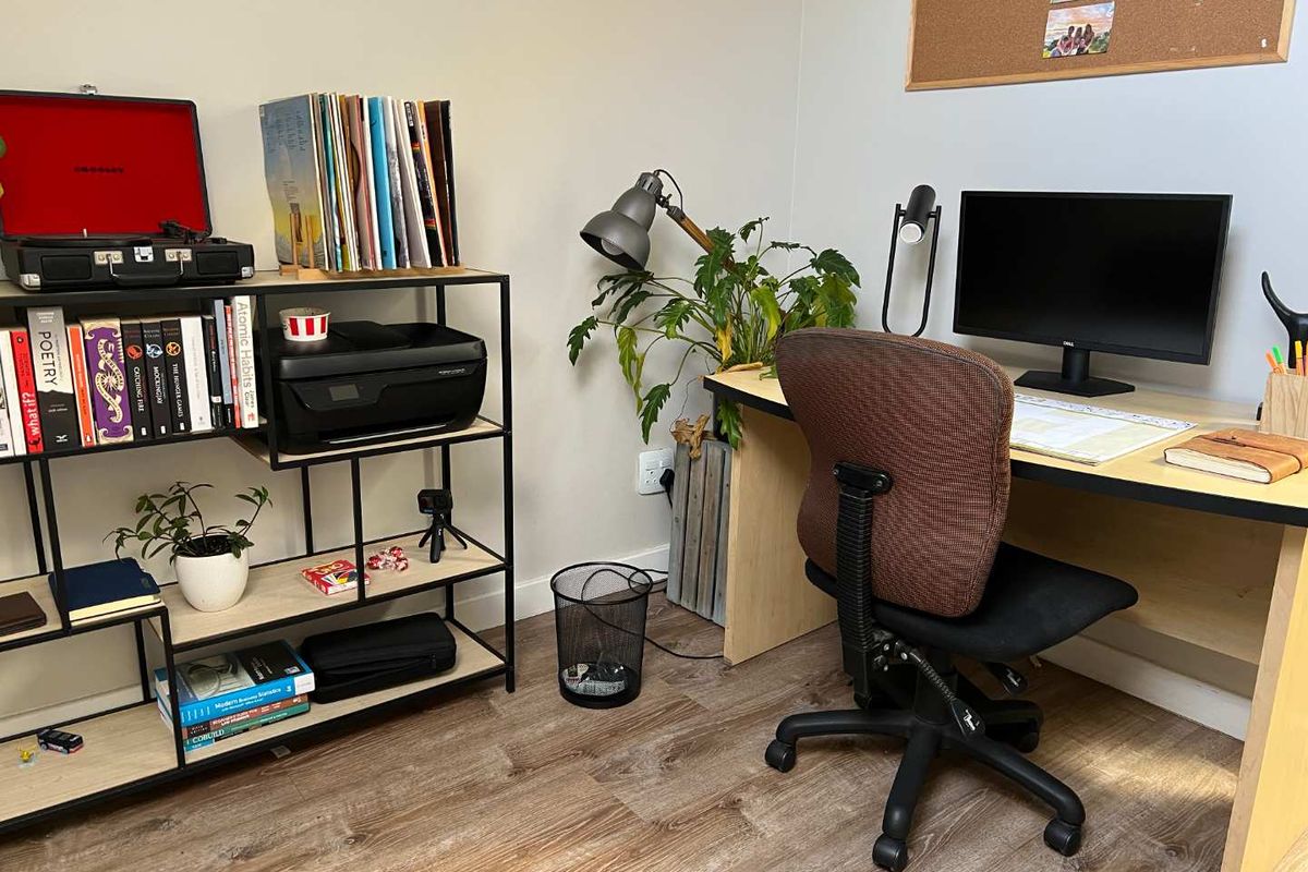 A functional home office space featuring wood-look laminate flooring and neutral wall finishes, suitable for a dedicated workspace.