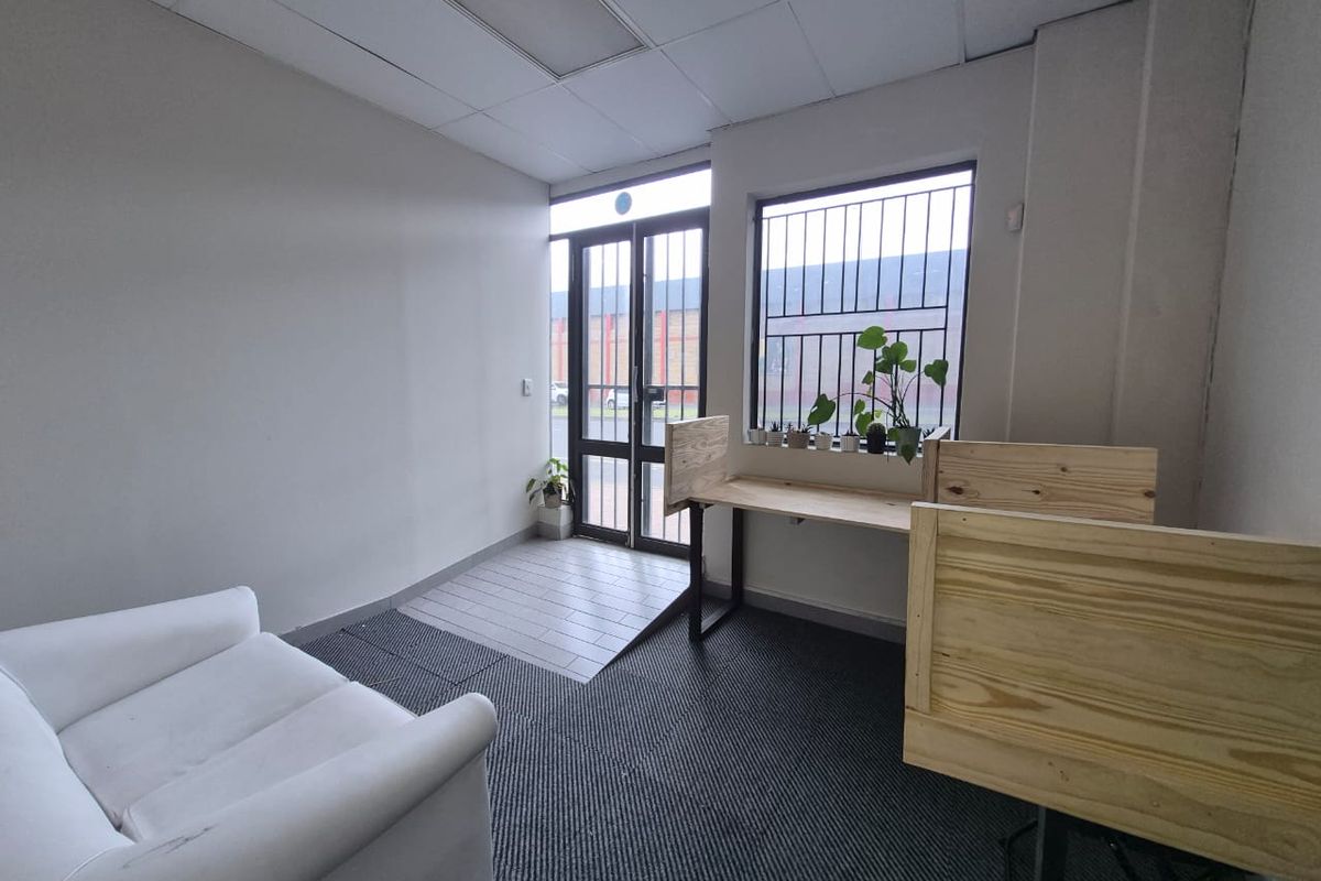 Entrance area featuring a security gate, tiled flooring at the threshold, carpeted main area, and security bars on the window.