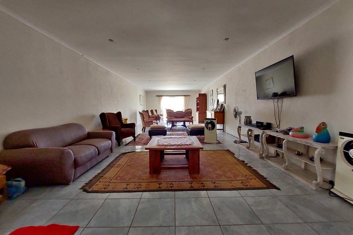 Spacious open-plan living area featuring neutral tiled flooring and recessed downlighting, providing a versatile layout for comfortable family living.