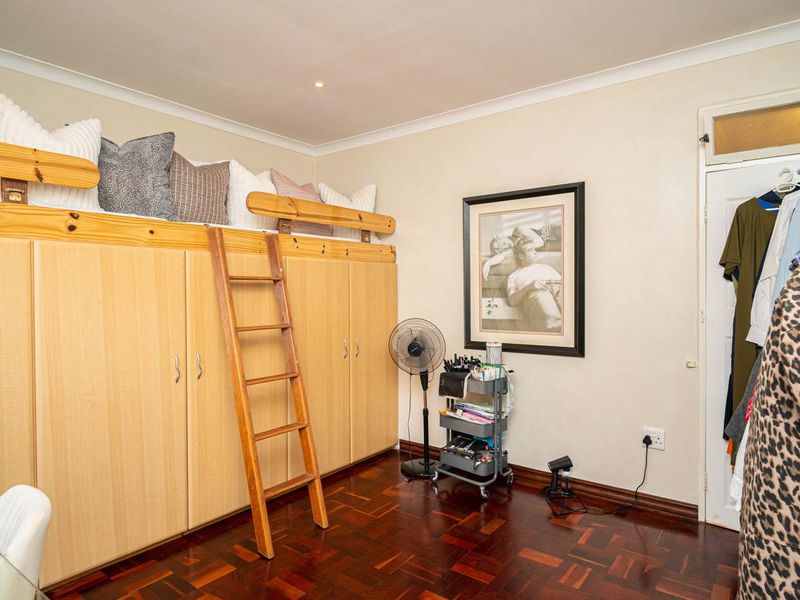 Bedroom featuring built-in cabinetry with an integrated loft bed, wooden ladder access, and traditional parquet flooring.