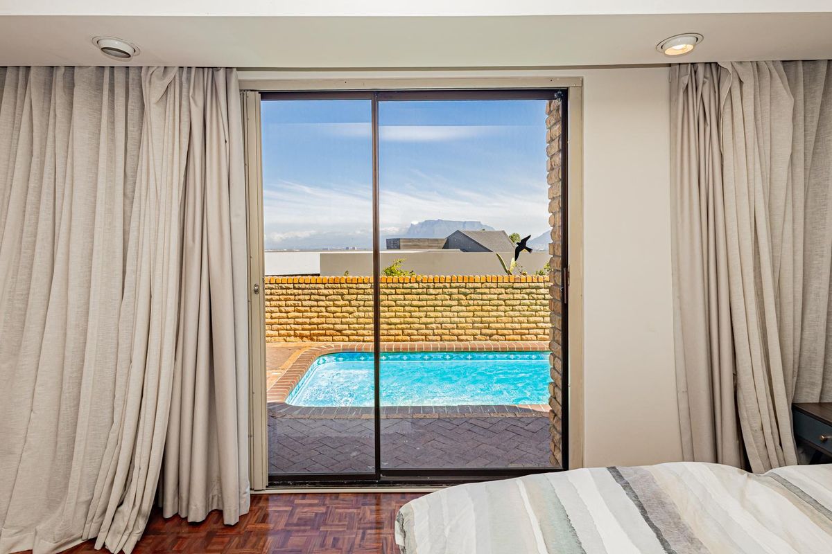 Bedroom featuring parquet flooring and a sliding glass door providing direct access to a private patio and swimming pool area.