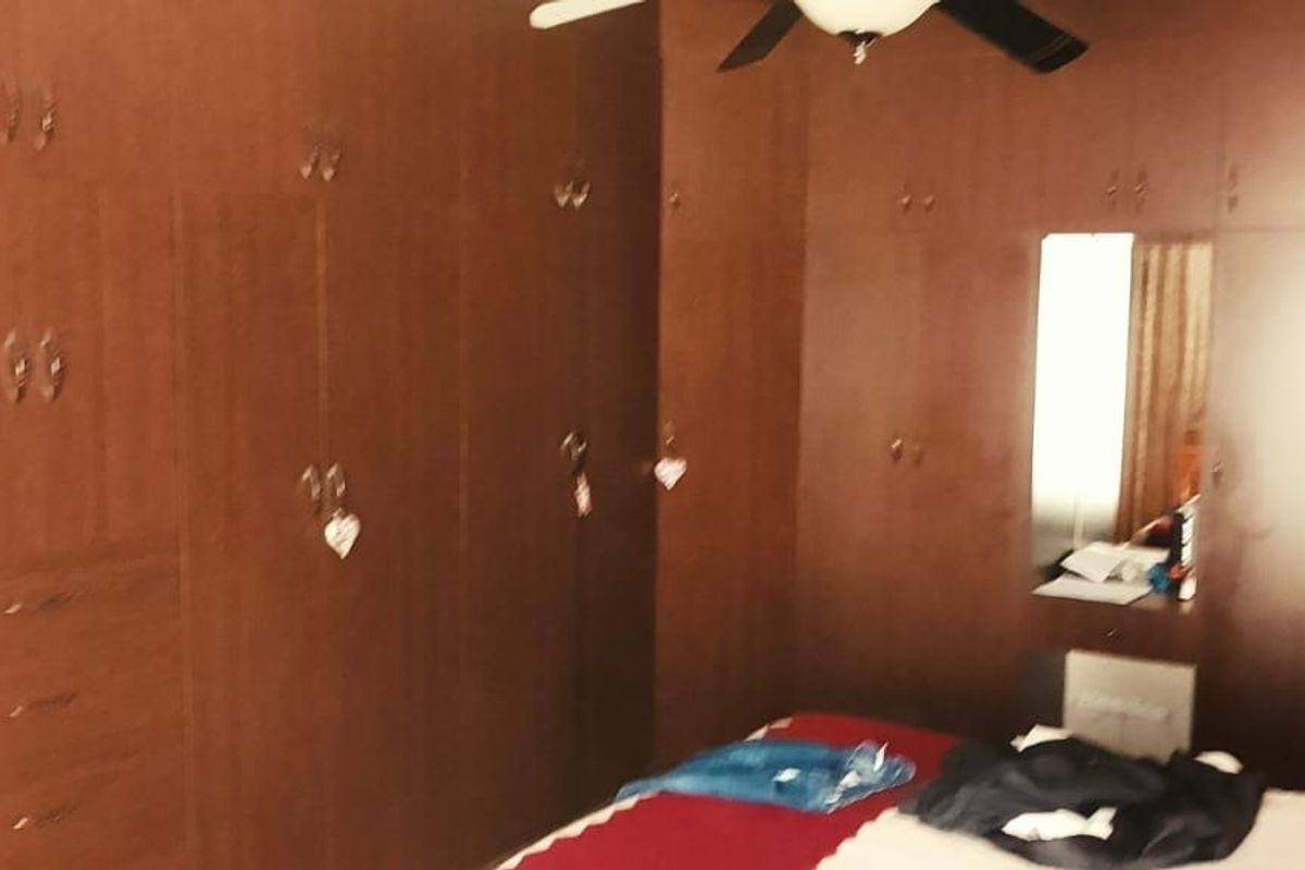 A bedroom featuring extensive built-in wooden cabinetry and a ceiling fan, providing ample storage space.