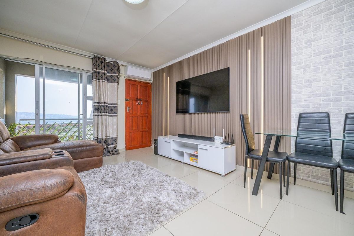 Modern living room featuring a stylish slatted timber accent wall with integrated lighting, tiled flooring, and direct access to a balcony.