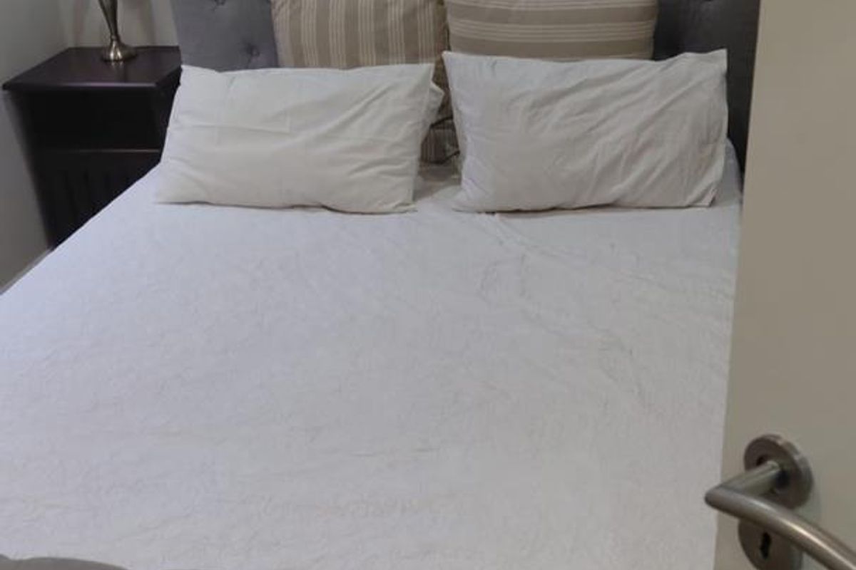 A bedroom featuring tiled flooring and a neutral interior, captured from the doorway.