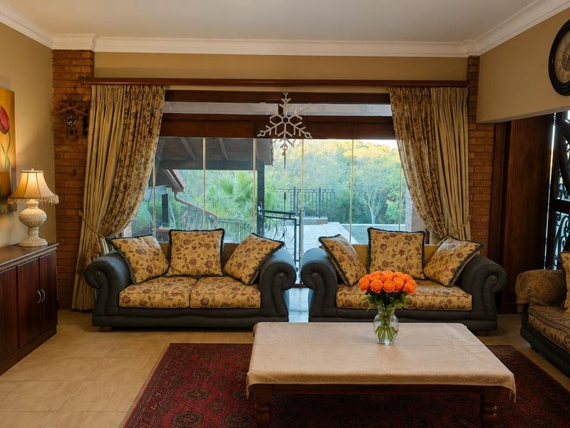 A comfortable living room featuring exposed brick accents, large glass sliding doors leading to an outdoor area, and tiled flooring.