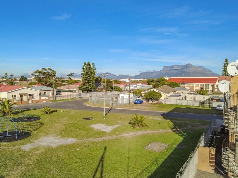 Elevated view overlooking the surrounding residential neighborhood, local park area, and distant mountain range.