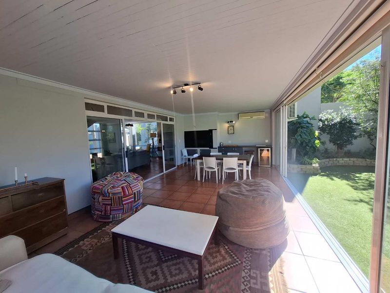 Spacious covered patio featuring tiled flooring, built-in bar area, and large sliding glass doors opening to a private garden.