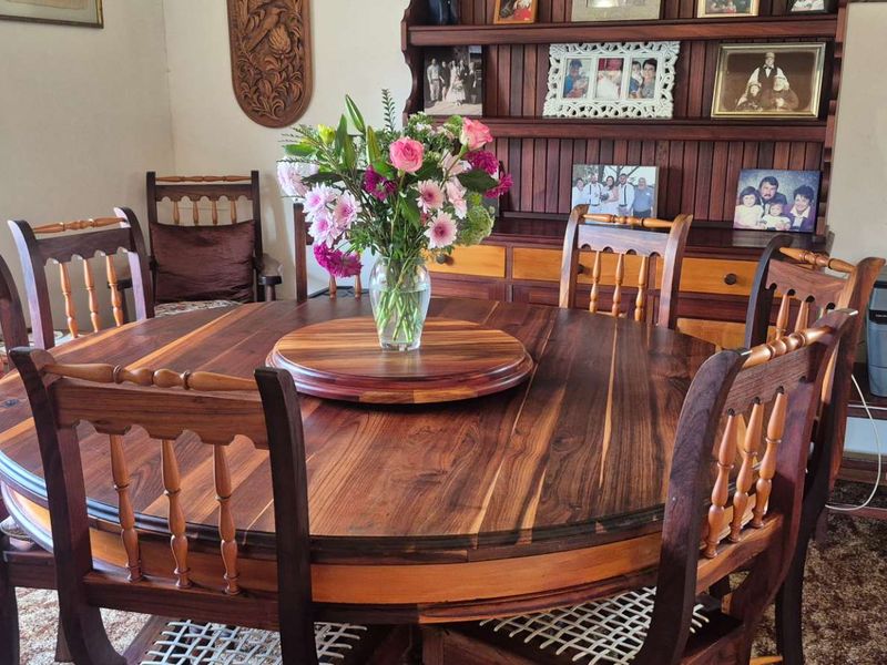 A traditional dining room featuring a built-in wooden hutch and carpeted flooring, offering a classic layout for family meals.