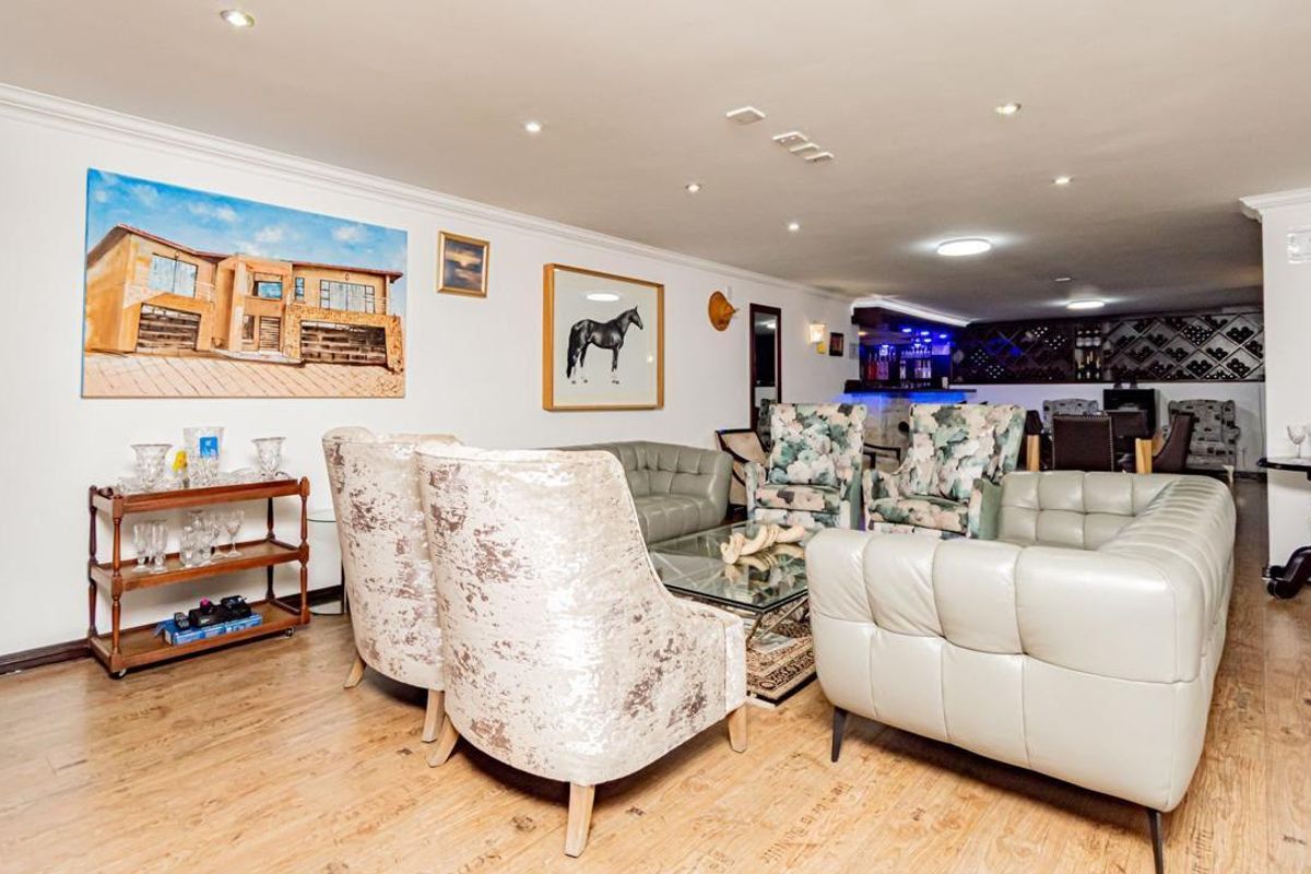Spacious living area featuring laminate flooring, recessed lighting, and a built-in bar with integrated wine storage.