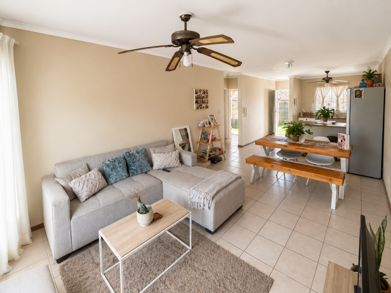 Open-plan living and dining area featuring tiled flooring, a ceiling fan, and a functional kitchen layout with an island.