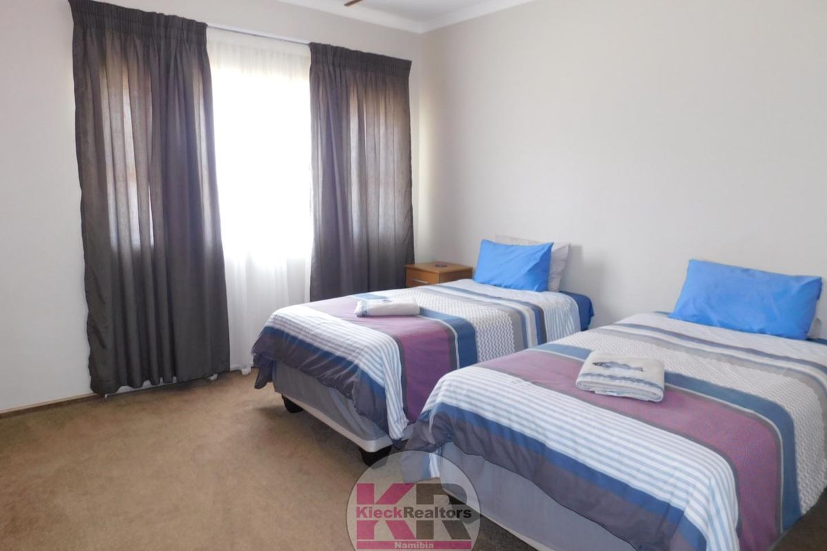 A functional bedroom featuring carpeted flooring and neutral wall finishes, providing a comfortable space with natural light from the window.