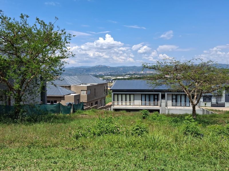 A view of the vacant residential land looking towards neighbouring properties and distant mountain landscape.