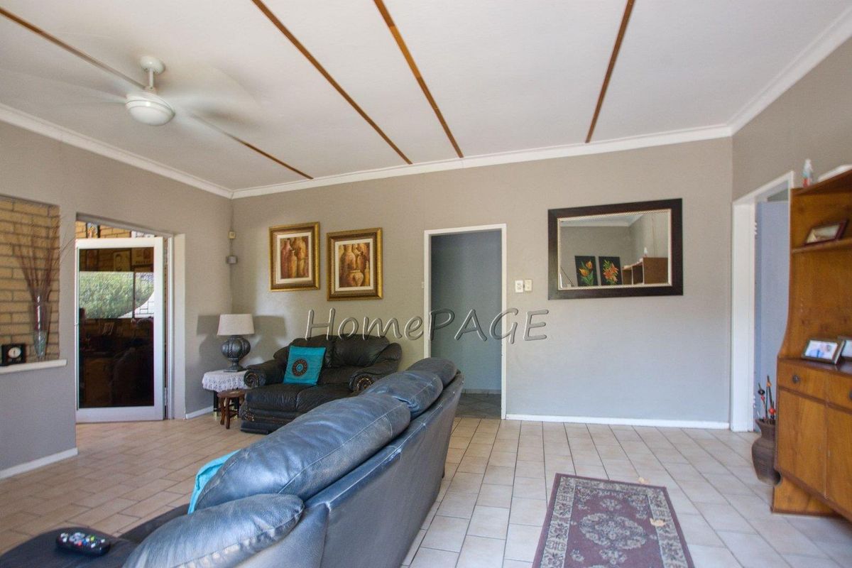Spacious living area featuring tiled flooring, a ceiling fan, and neutral wall tones, providing a functional and versatile space for relaxation.