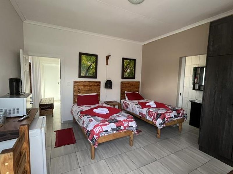 A bedroom featuring tiled flooring and a built-in wardrobe, with direct access to an adjoining bathroom area.