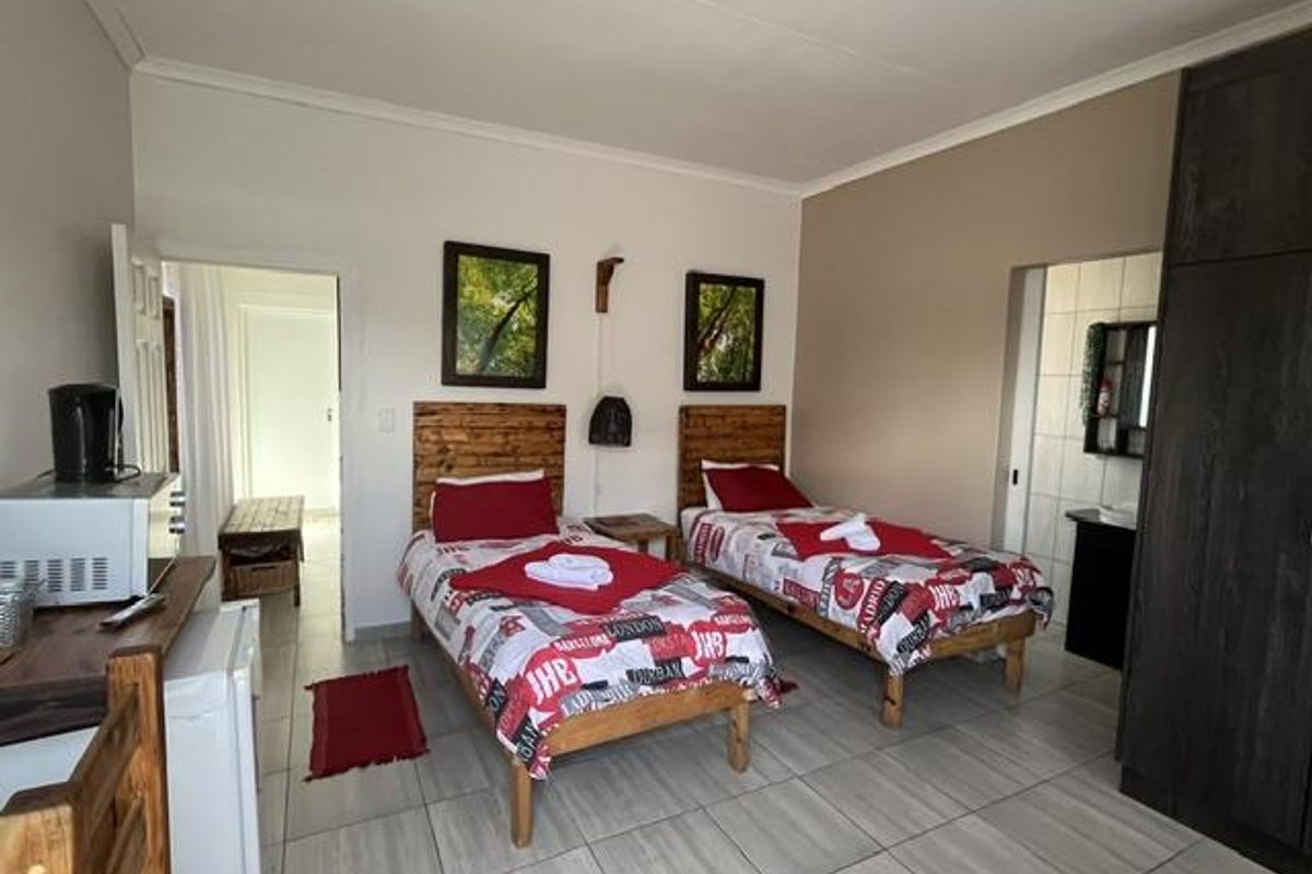 A bedroom featuring tiled flooring and a built-in wardrobe, with direct access to an adjoining bathroom area.