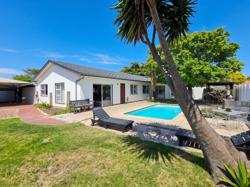 Rear view of the property featuring a swimming pool, paved patio area, and direct access to the home via sliding glass doors.