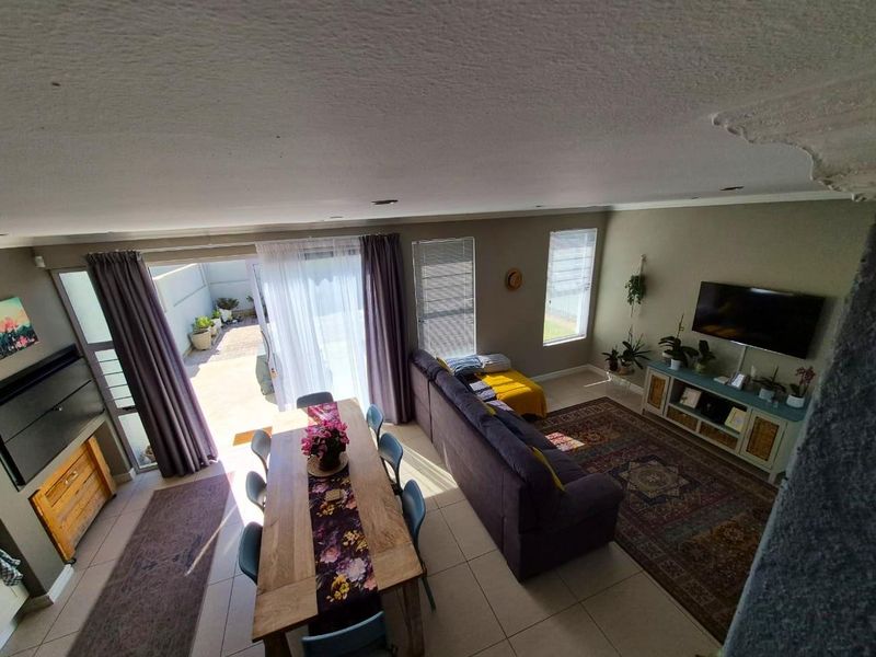 Spacious open-plan living and dining area featuring tiled flooring, recessed lighting, and large sliding doors providing direct access to the outdoor patio.