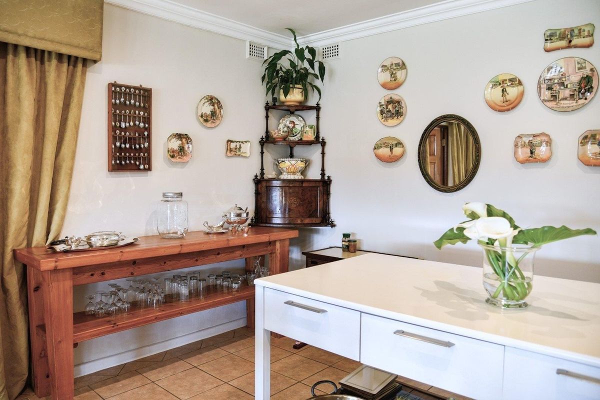 A functional kitchen space featuring tiled flooring, crown molding, and a mix of wooden and modern white cabinetry elements.