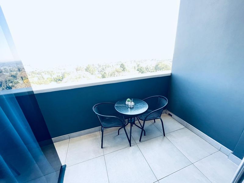 A private balcony featuring tiled flooring and a solid balustrade, offering an elevated outdoor space with scenic views.