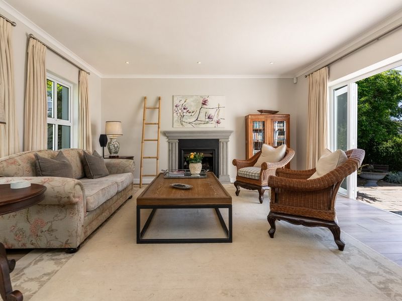 A bright and inviting living room featuring a stone fireplace, recessed lighting, and large sliding glass doors that open onto an outdoor patio area.