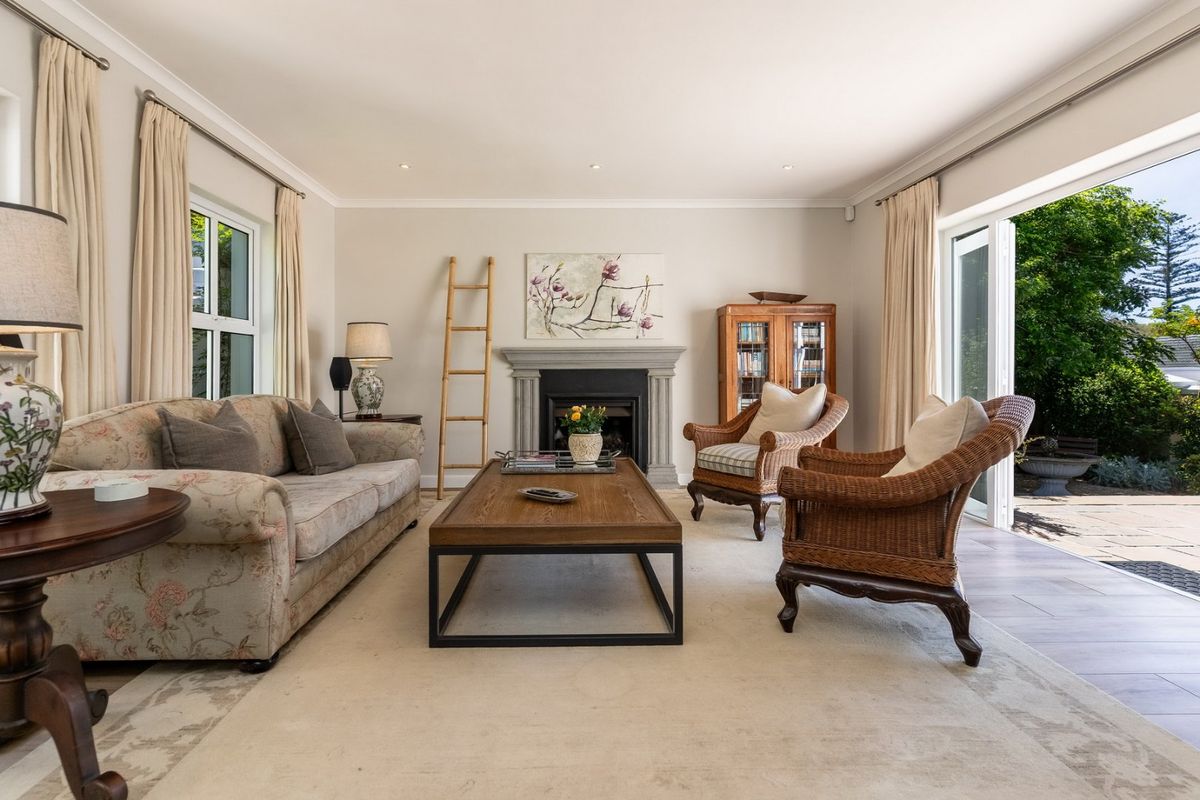 A bright and inviting living room featuring a stone fireplace, recessed lighting, and large sliding glass doors that open onto an outdoor patio area.