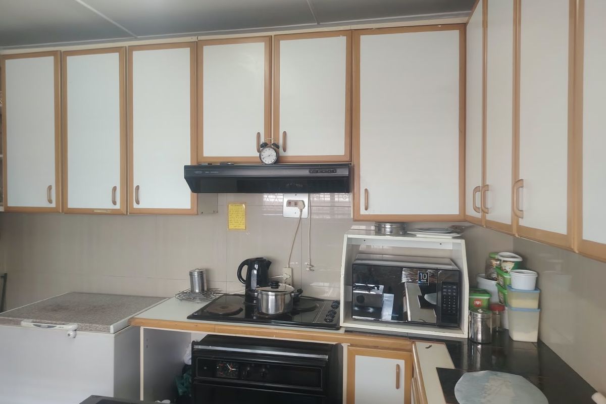 A functional kitchen featuring white cabinetry with wood trim, a built-in oven, electric hob, and tiled backsplash.