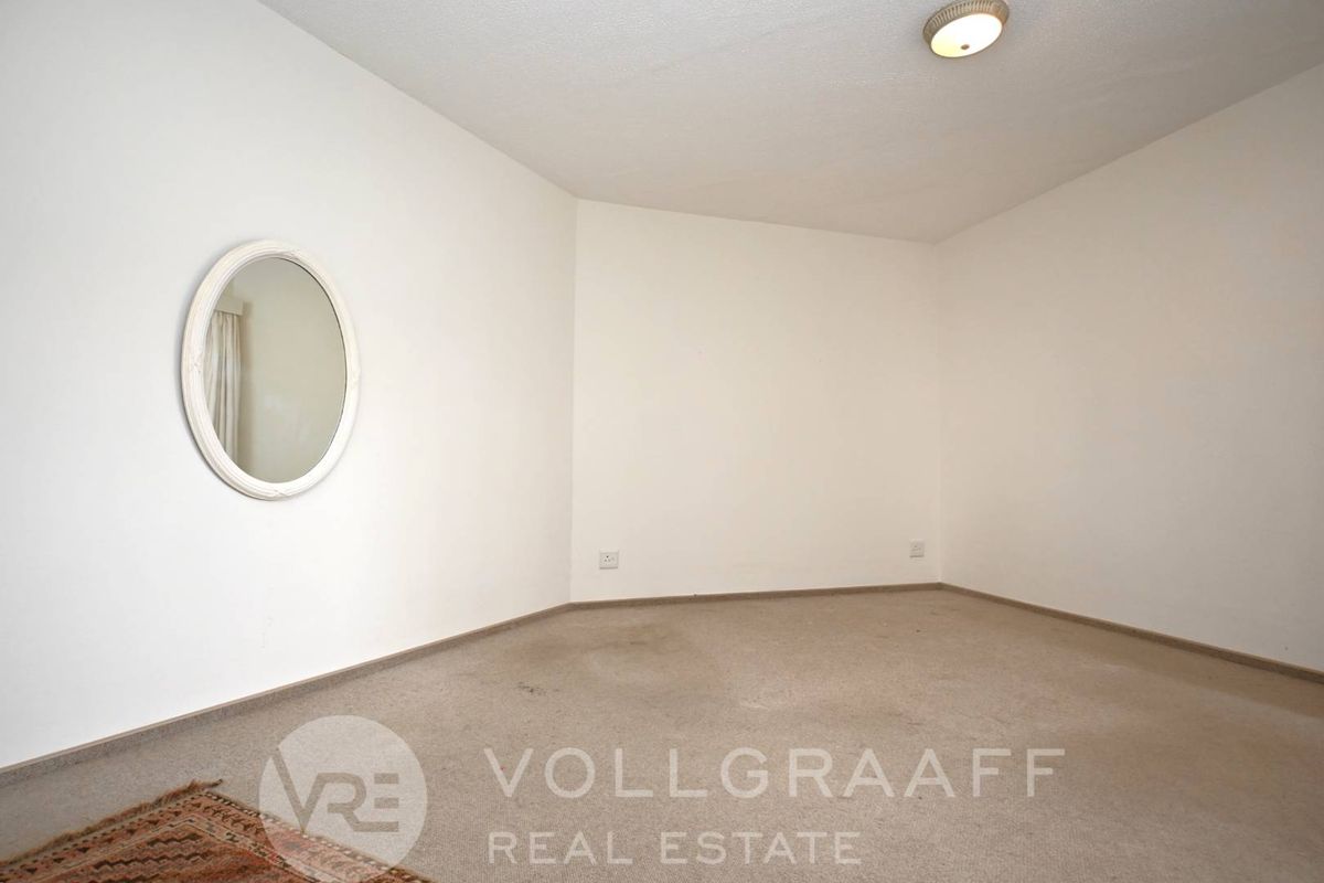 An empty bedroom featuring neutral walls, carpet flooring, and a flush mount ceiling light fixture.
