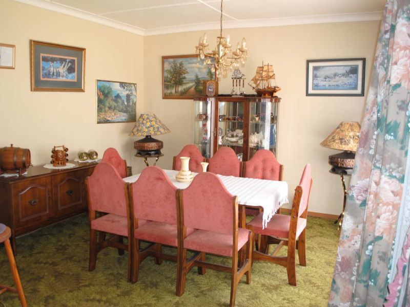A traditional dining room featuring coving and a central chandelier, offering a functional space for family meals and entertaining.