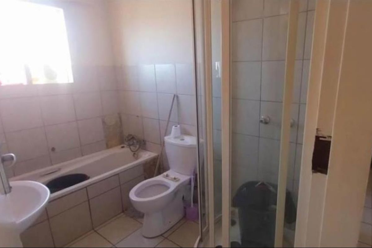A functional bathroom featuring a bathtub, separate shower enclosure, pedestal basin, and toilet with tiled flooring and wall finishes.